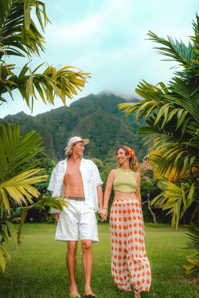 couple holding hands in front of hoomaluhia botanical garden